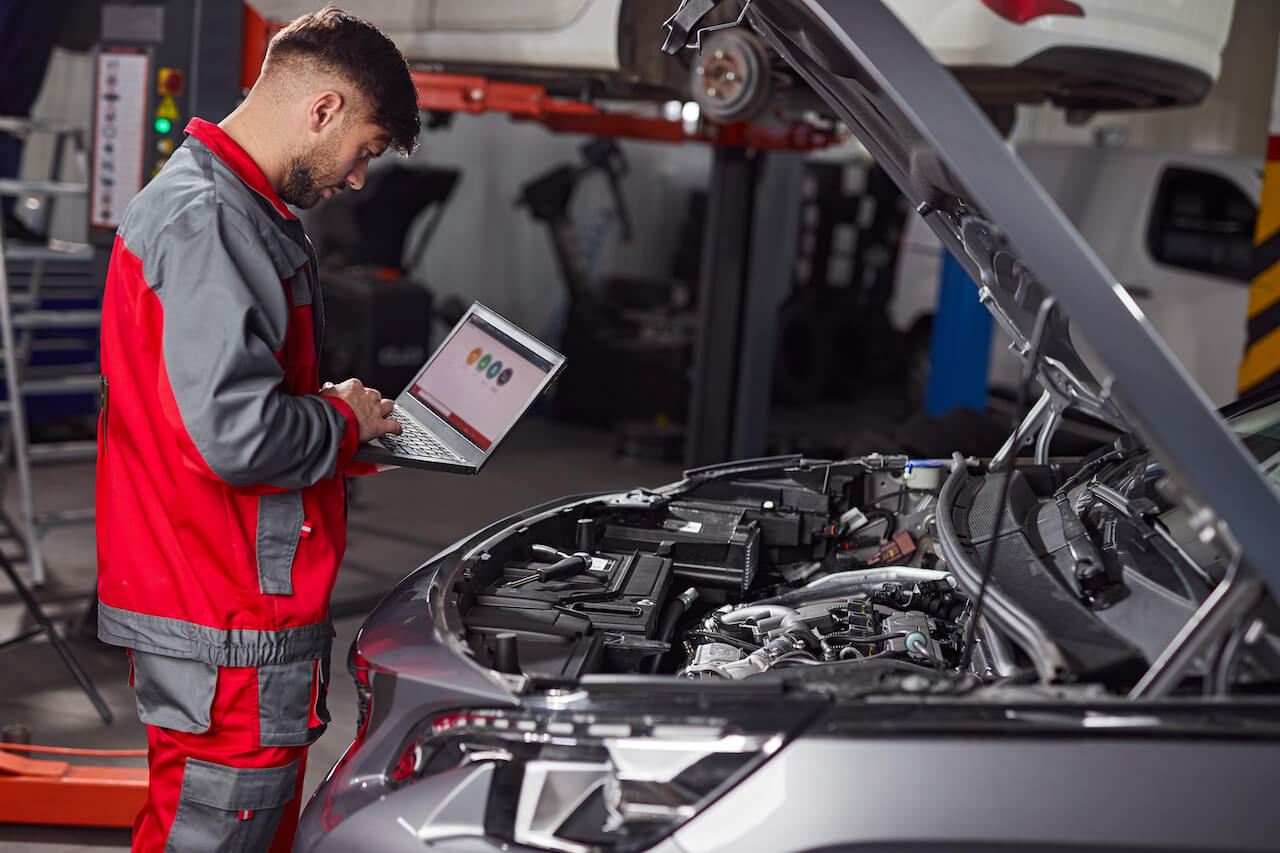 mechanic-using-laptop-and-inspecting-car-in-servic-2023-11-27-05-11-39-utc (1)